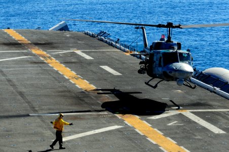 US Navy 101104-N-3659B-086 An aviation boatswain's mate (handling) gives hand signals to land an AH-1 Cobra assigned to the Evil Eyes of Marine Med