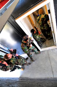 US Navy 101106-N-4044H-025 Navy SEALs enter a simulated home while practicing close quarters combat at U.S. Training Center Moyock