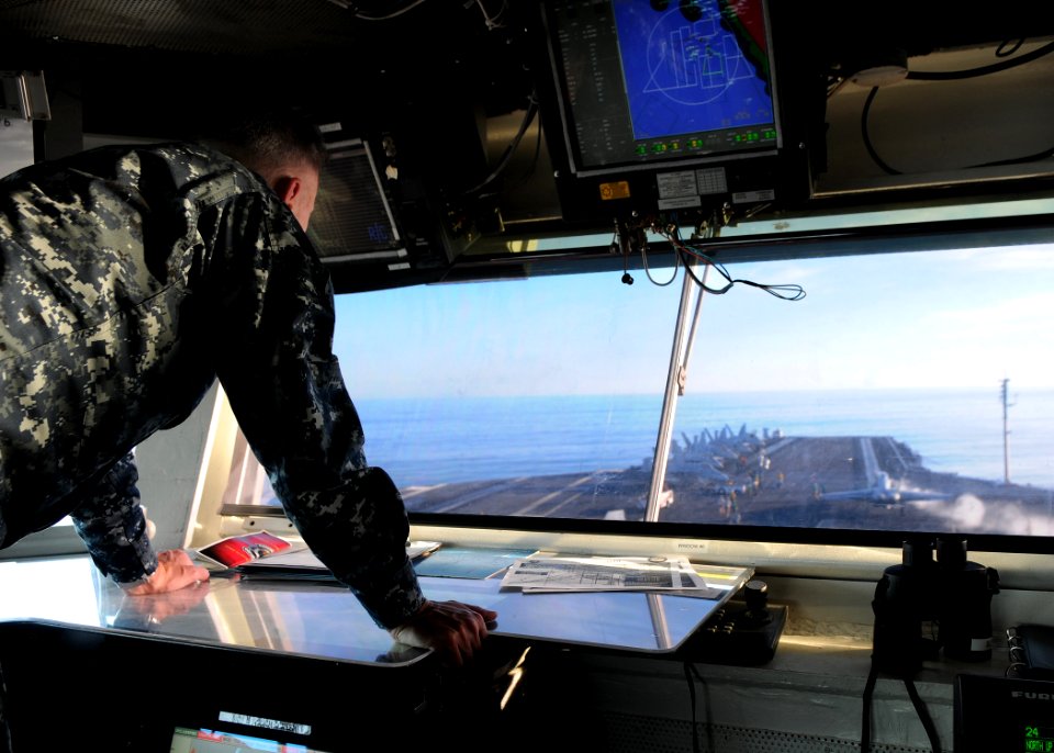 US Navy 101105-N-1004S-105 Capt. Thom Burke, commanding officer of the aircraft carrier USS Ronald Reagan (CVN 76), watches from the bridge as Comm