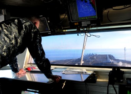 US Navy 101105-N-1004S-105 Capt. Thom Burke, commanding officer of the aircraft carrier USS Ronald Reagan (CVN 76), watches from the bridge as Comm