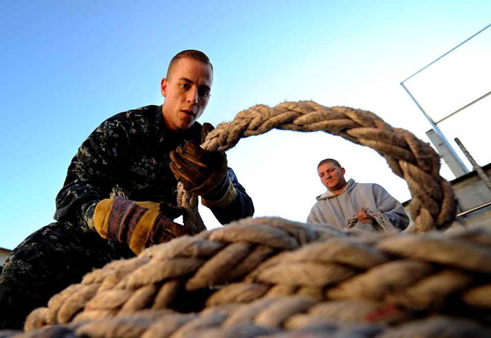 US Navy 101106-N-2984R-112 Seaman Timothy Dawson and John Wahl, a merchant mariner, both assigned to High Speed Vessel Swift (HSV 2), coil lines as