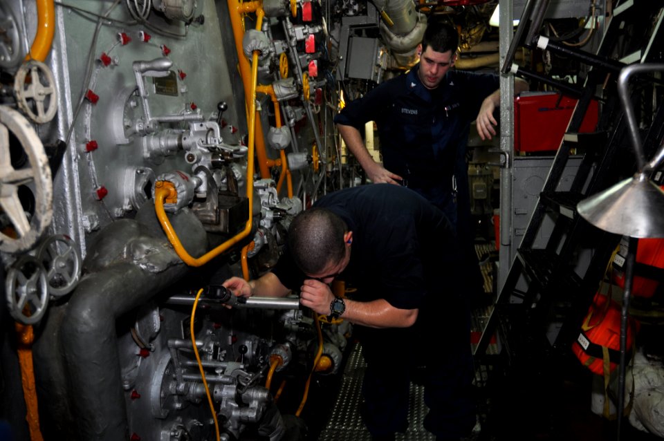 US Navy 101107-N-7293M-241 Machinist's Mate 3rd Class Shawn Stevens watches as Machinist's Mate Fireman Lucas Torres uses a furnace inspection devi