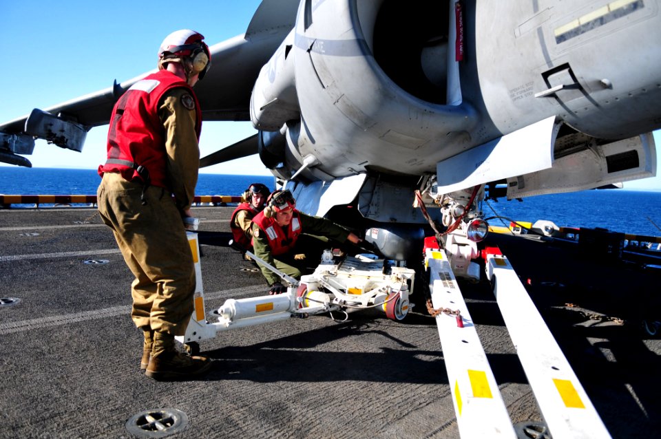 US Navy 101111-N-1722W-021 Cpl. John Lee, left, Cpl. Eric Perez, and Cpl. Kevin Kahn install a lightning pod on an AV-8B Harrier from the Evil Eyes