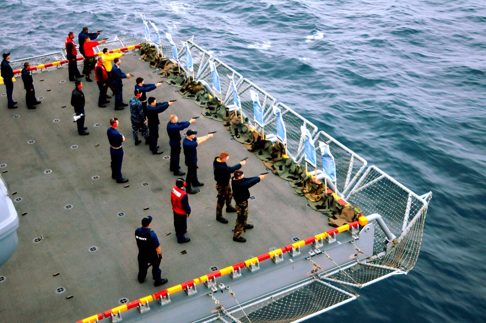 US Navy 101106-N-1722W-011 Sailors fire M-9 9 mm pistols during a small-arms qualification on an aircraft elevator aboard the amphibious assault sh