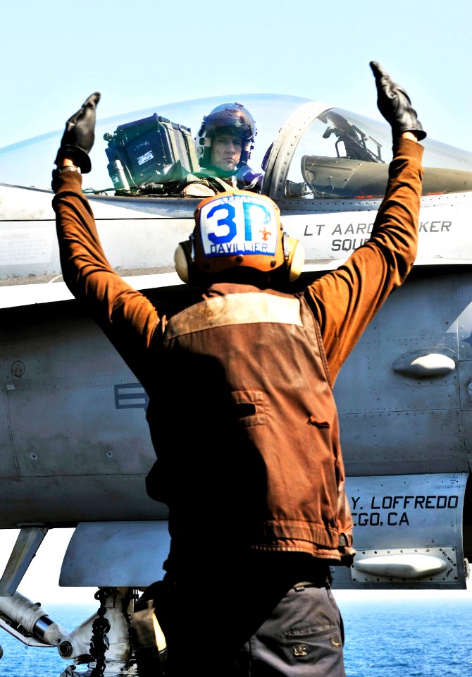 US Navy 101111-N-6003P-203 Capt. James Bynum, commander of Carrier Air Wing (CVW) 3, looks to his plane captain, Aviation Structural Mechanic Airma