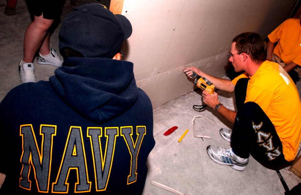 US Navy 101108-N-7948C-042 Sailors assigned to the guided-missile destroyer Pre-Commissioning Unit (PCU) Jason Dunham (DDG 109), hang drywall durin