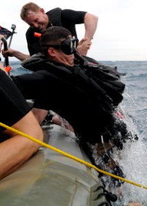 US Navy 101108-N-0120A-076 Boatswain's Mate 1st Class Kurt Bartholomai helps Aviation Warfare Systems Operator 2nd Class Ricky Crumley into a rigid