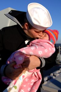 US Navy 101107-N-5292M-050 Cryptologic Technician (Technical) 3rd Class Carl Perry kisses his four-month-old daughter good-bye aboard the guided-mi