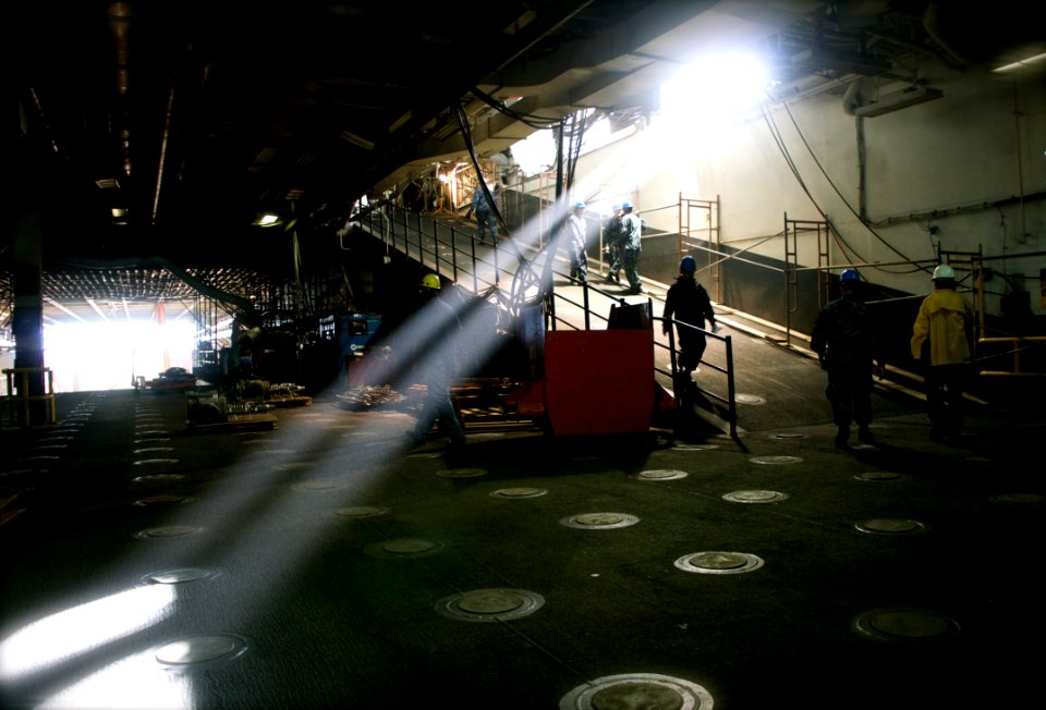 US Navy 101108-N-9643K-246 Sunshine streams into the upper vehicle deck of the amphibious assault ship USS Bonhomme Richard (LHD 6) as Sailors and