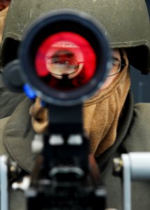 US Navy 101112-N-2218S-015 unner's Mate 2nd Class Anthony Chenoweth looks through the sight of a Mk-38 25 mm gun during a training exercise aboard