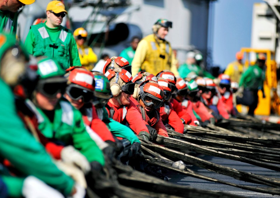 US Navy 101109-N-6003P-175 Sailors and Marines heave in a barricade net during a crash barricade deployment drill aboard the aircraft carrier USS H