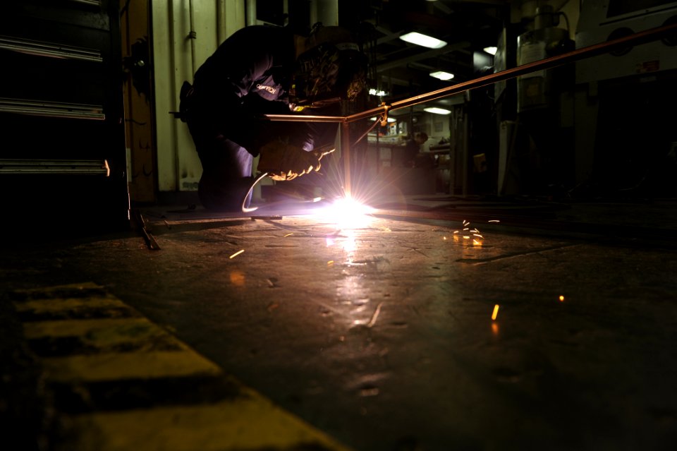 US Navy 101111-N-6427M-099 Hull Maintenance Technician Fireman Apprentice Daniel Younkvich, from Shelbyville, Ind., arc welds a frame for storage s