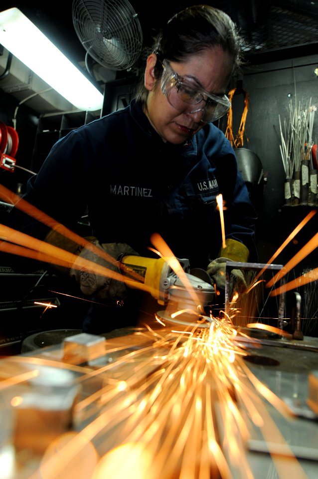 US Navy 101108-N-9132C-022 Hull Maintenance Technician 3rd Class Nelly Martinez grinds a TV bracket in the welding shop aboard the aircraft carrier