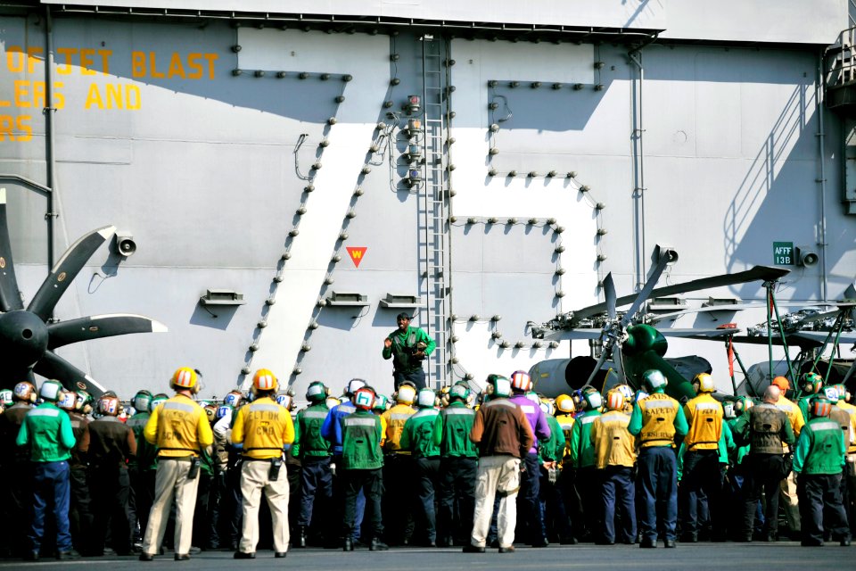 US Navy 101109-N-6003P-132 Aviation Boatswain's Mate (Equipment) 3rd Class Timothy Johnson, addresses flight deck crew members before a crash barri
