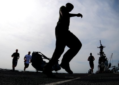 US Navy 101109-N-5538K-128 Marines assigned to the 31st Marine Expeditionary Unit (31st MEU) run on the flight deck of the forward-deployed amphibi photo