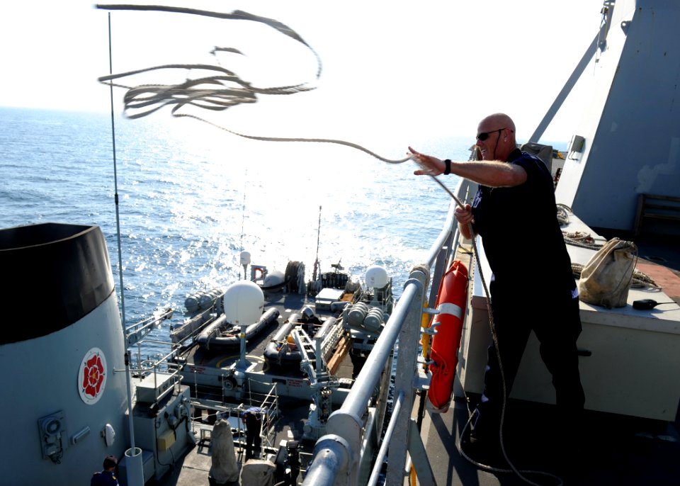 US Navy 101113-N-6266K-026 Ray Delbridge, assigned to the Royal Fleet Auxiliary landing ship Lyme Bay (L3007), throws a line to the Royal Navy mine