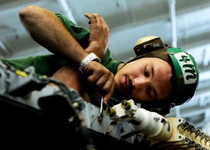 US Navy 101113-N-6427M-006 Aviation Structural Mechanic Airman Justin Klippert, from Ontario, Canada, installs a leading edge flap transmission ass