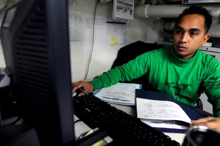 US Navy 101113-N-9132C-053 Aviation Boatswain's Mate 1st Class Rick Maghanoy, from Temecula, Calif., processes a leave form in the air department V