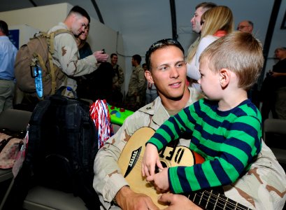 US Navy 101113-N-4267W-109 Intelligence Specialist 1st Class Joshua Mathias, assigned to Riverine Squadron (RIVRON) 1, sits with his son at the Nav