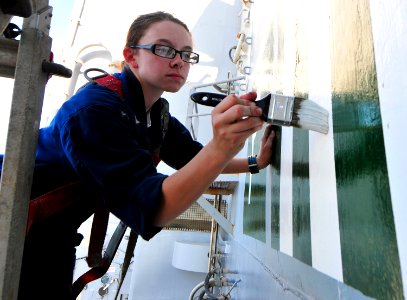 US Navy 101113-N-7948R-106 Boatswain's Mate 3rd Class Amanda Achman, from Fairbanks, Alaska, paints the edge of the deck at a refuel station aboard