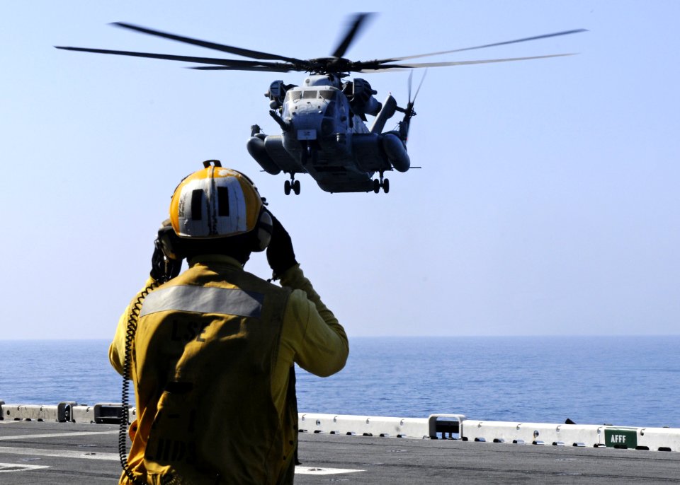 US Navy 101116-N-3154P-072 Aviation Boatswain's Mate (Handling) 3rd Class David Neiman directs a CH-53E Super Stallion helicopter assigned to Marin