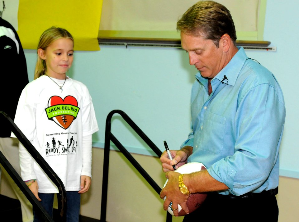US Navy 101116-N-5516S-001 Jack Del Rio, Jacksonville Jaguars head coach, autographs a football for a participant in the Jack Del Rio Foundation's