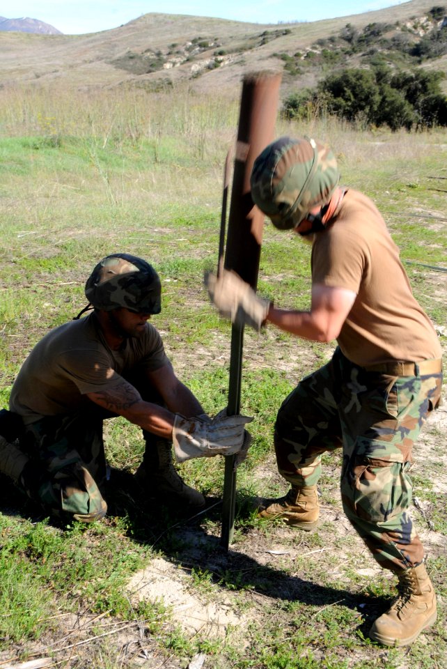 US Navy 101114-N-1786N-057 Boatswain's Mates 2nd Class Eddis Ramirez, left, and Craig Richmond prepare to set a perimeter with concertina wire duri