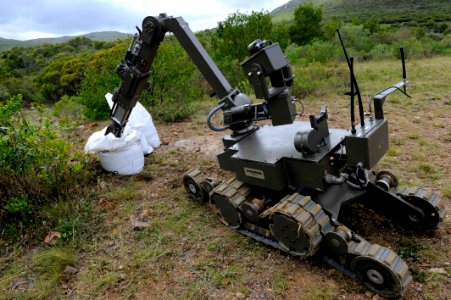 US Navy 101116-N-8546L-850 Uruguayan explosive ordnance disposal technicians remotely operate an ANDROS robot to examine a secondary improvised exp photo