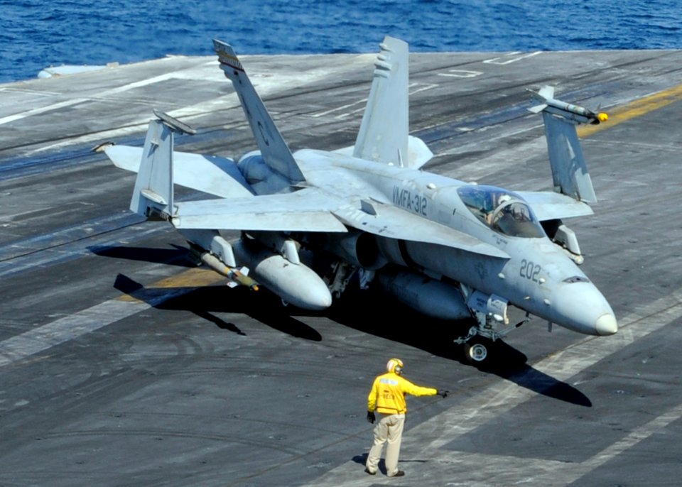 US Navy 101114-N-6427M-074 A plane director guides the pilot of an F-A-18C Hornet as it taxis across the flight deck aboard the aircraft carrier US
