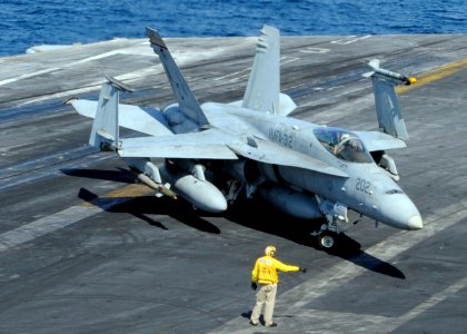 US Navy 101114-N-6427M-074 A plane director guides the pilot of an F-A-18C Hornet as it taxis across the flight deck aboard the aircraft carrier US