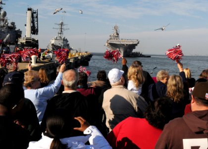 US Navy 101118-N-6125G-045 Family members cheer as the amphibious assault ship USS Iwo Jima (LHD 7) returns to Naval Station Norfolk after a four-m