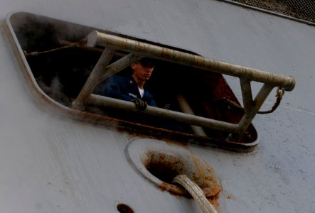 US Navy 101116-N-3852A-140 A Sailor assigned to the amphibious assault ship USS Nassau (LHA 4) observes line handlers during preparations for getti