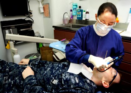 US Navy 101115-N-3705H-125 Hospital Corpsman 3rd Class Jodie Stump performs a routine teeth cleaning on a patient in the dental department aboard t