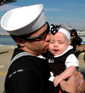 US Navy 101118-N-9806M-182 Aviation Boatswain's Mate (Handling) 3rd Class Zachary Herndon kisses his newborn daughter at Naval Station Norfolk