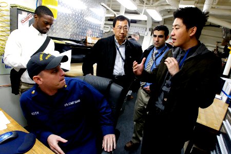 US Navy 101119-N-8863V-143 Tim Zhang, right, confers with U.S. Coast Guard Gunner's Mate 1st Class Jason Keith as Anthony Oyatayo, left, James Chai