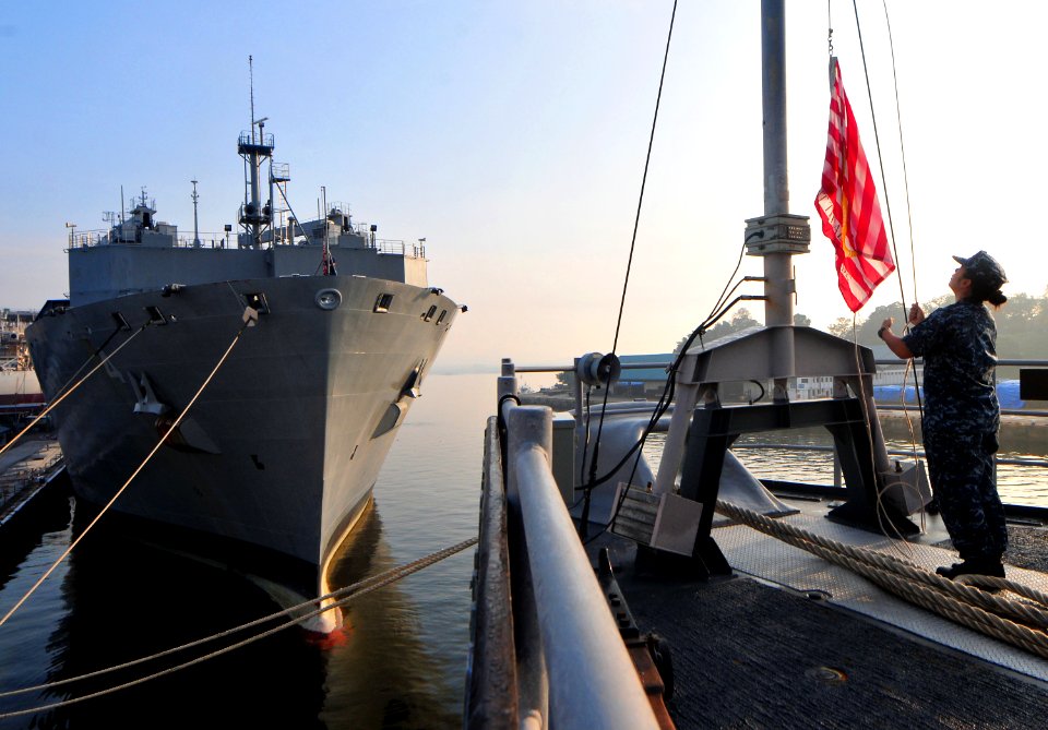 US Navy 101121-N-7948R-001 Ship's Serviceman 3rd Class Jennifer Ann Redondo raises the Navy Jack during morning colors aboard the amphibious dock l