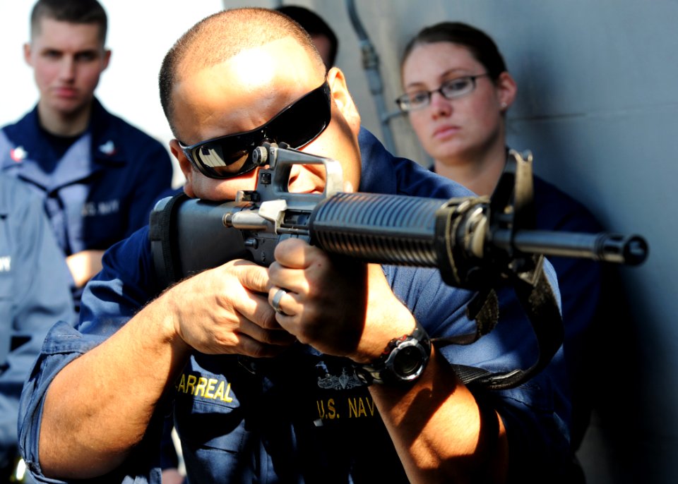 US Navy 101120-N-6499D-025 Chief Gunner's Mate Javier Villarreal demonstrates proper M-16 service rifle techniques during training aboard the guide