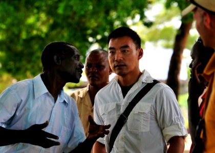US Navy 101117-N-7241L-001 U.S. Navy Lt. Perry Choi, right, team leader for Maritime Civil Affairs Team (MCAT) 205, speaks with Samuel Iha, chairma
