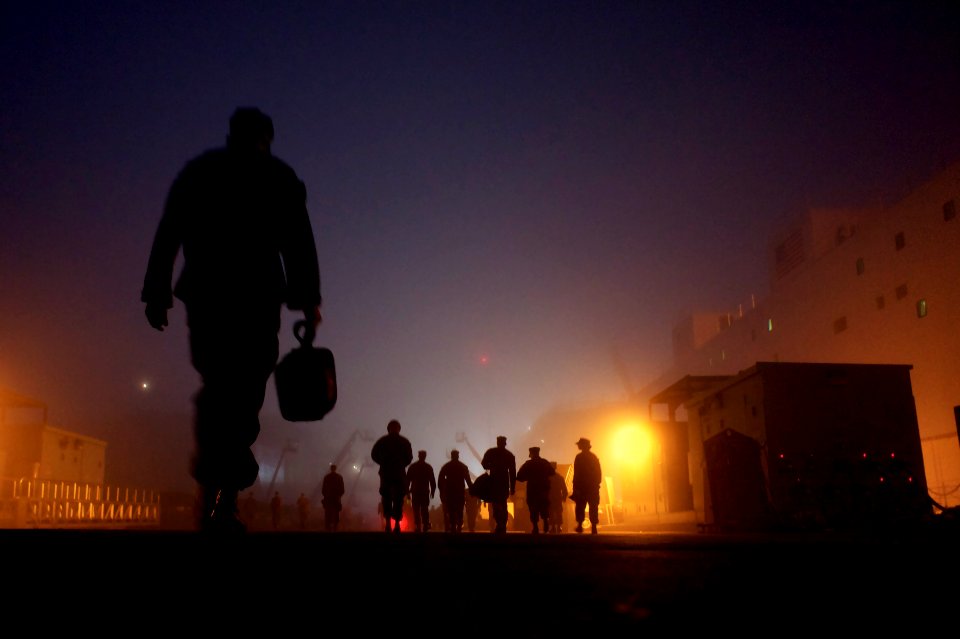 US Navy 101118-N-9643K-771 Sailors assigned to the amphibious assault ship USS Bonhomme Richard (LHD 6) walk through early morning fog to the ship