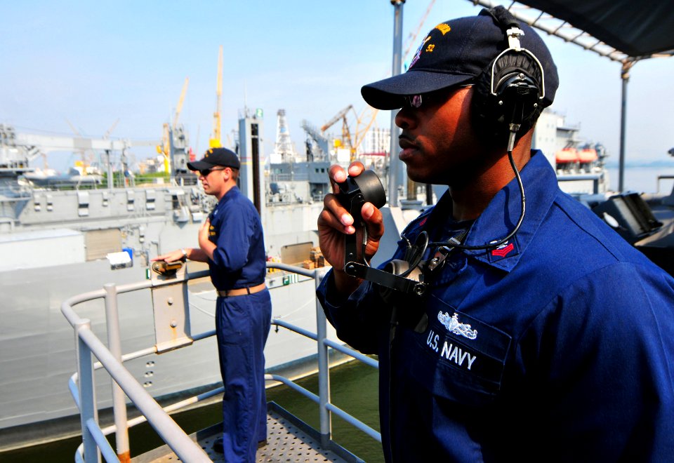 US Navy 101121-N-7948R-063 Yeoman 1st Class Jason McClinton talks on a sound powered phone aboard the amphibious dock landing ship USS Pearl Harbor