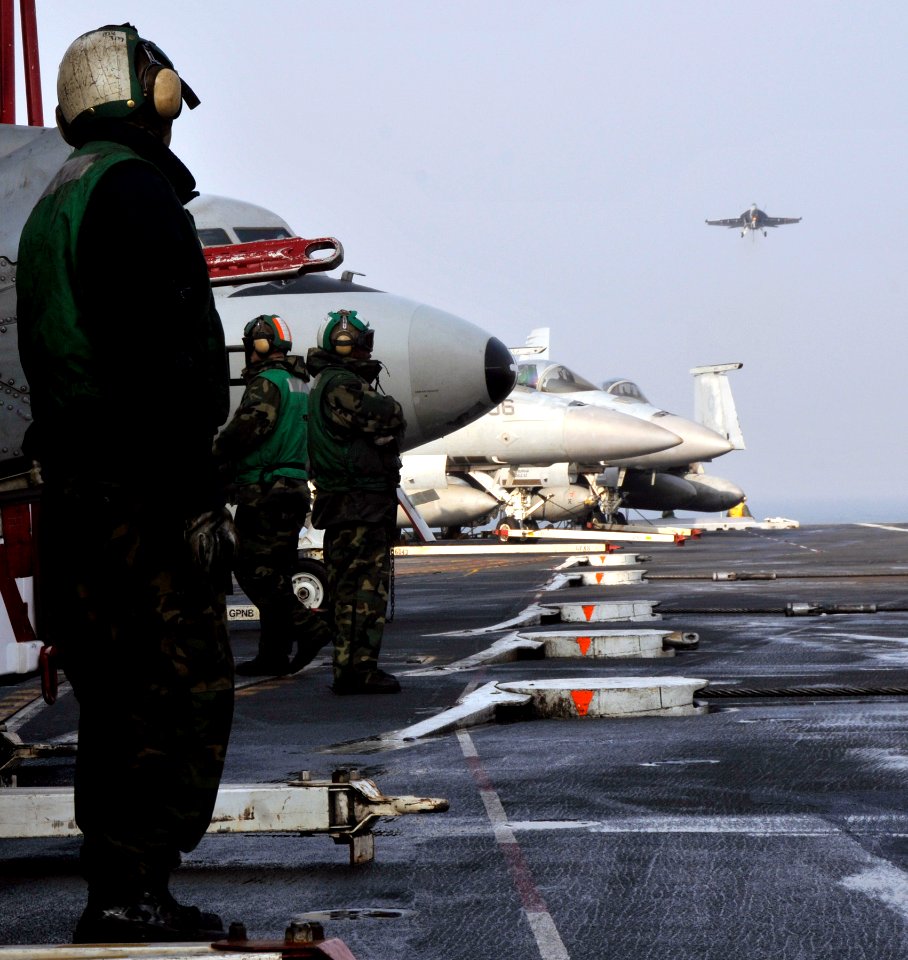 US Navy 101129-N-7103C-029 Aviation Boatswain's Mates (Handling) await the arrival of a Super Hornet on the flight deck aboard the aircraft carrier