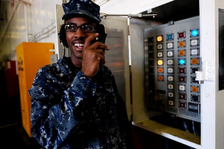 US Navy 101122-N-9132C-017 Aviation Ordnanceman Airman Wesley Smith, from Pittsburgh, acts as a weapons elevator operator in the hangar bay of the
