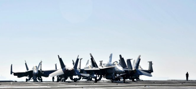 US Navy 101201-N-6003P-069 A Sailor walks past F-A-18 Hornet strike fighters on the flight deck of the aircraft carrier USS Harry S. Truman (CVN 75