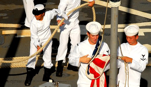US Navy 101130-N-7498L-132 Sailors lower the ensign aboard the guided-missile destroyer USS Paul Hamilton (DDG 60) as the ship prepares for departu