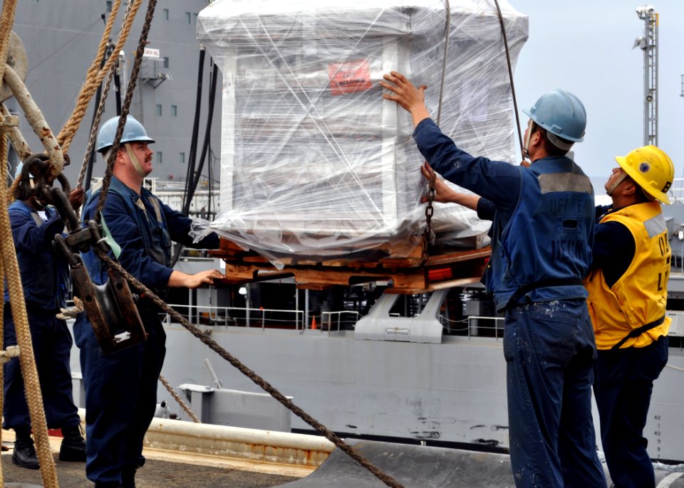 US Navy 101122-N-3620B-025 Sailors aboard the amphibious transport dock ship USS Denver (LPD 9) lower a pallet of stores during a replenishment at