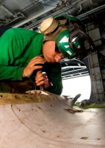 US Navy 101126-N-9626Y-035 Aviation Structural Mechanic 3rd Class Luke Spataro, from St. Louis, performs corrosion control on an F-A-18E Super Horn