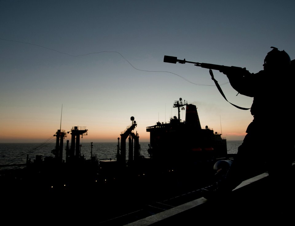 US Navy 101201-N-7981E-111 Gunner's Mate 2nd Class John Brown fires a shot line to the Military Sealift Command fleet replenishment oiler USNS Yuko