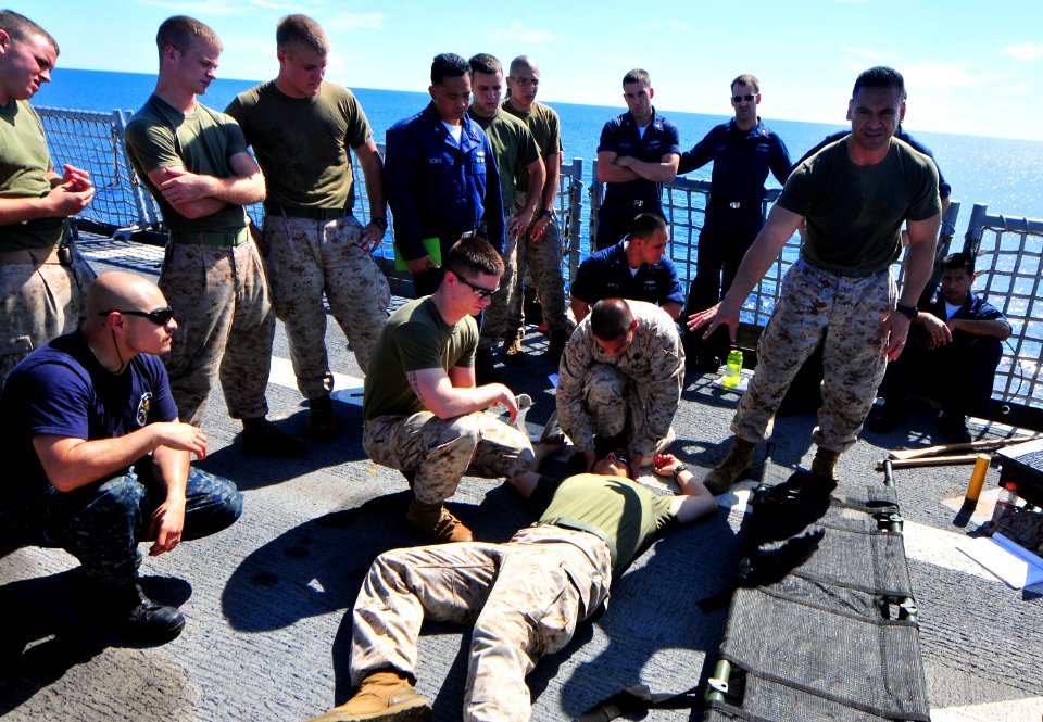 US Navy 101124-N-7948R-171 Chief Hospital Corpsman Lorch Toloumu explains how to properly move a patient on a stretcher during a combat life savers