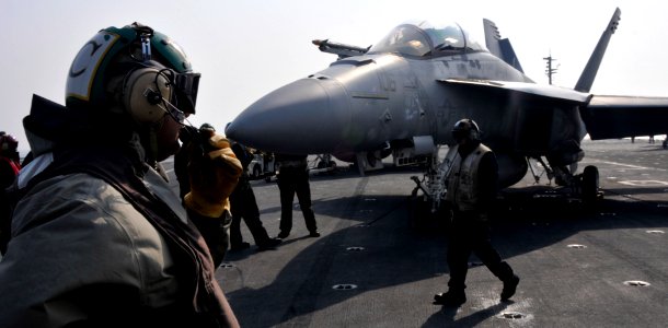 US Navy 101129-N-7103C-111 Aviation Boatswain's Mates (Handling) assigned to the Diamondbacks of Strike Fighter Squadron (VFA) 102 maneuver an F-A