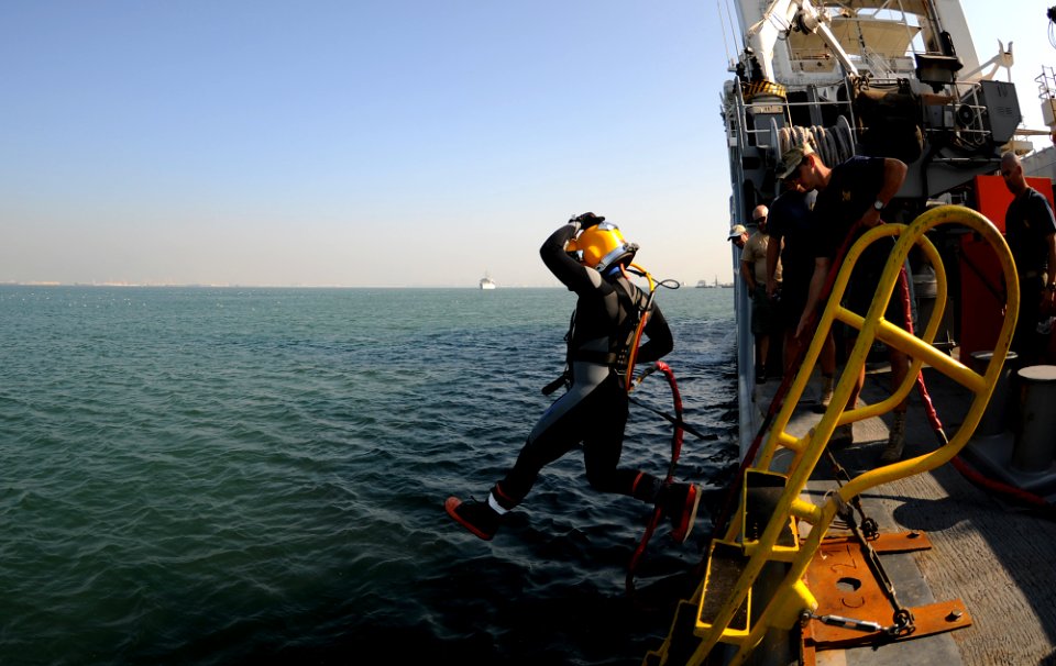 US Navy 101202-N-0413B-139 Navy Diver 2nd Class Malachi Greiner, assigned to Mobile Diving and Salvage Unit (MDSU) 2, steps off the deck of the Mil